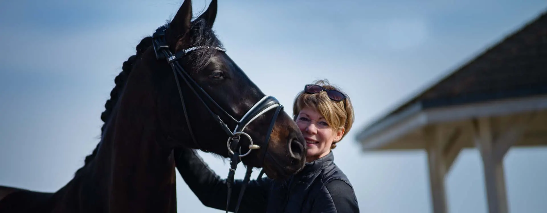 Portrait von Karen van Hunnik-Bretfeld mit schwarzem Pferd